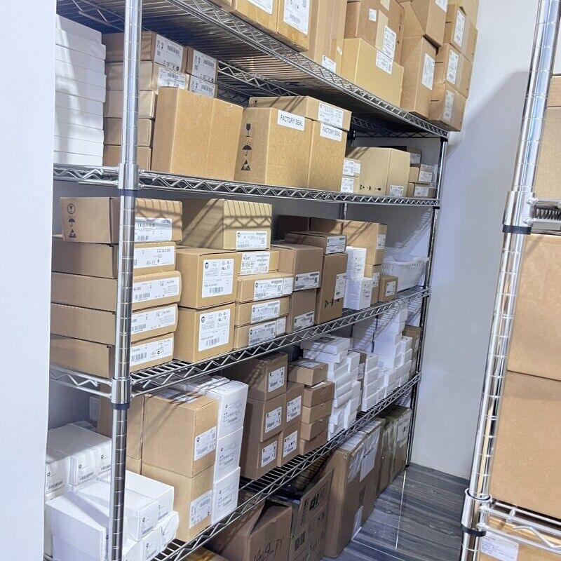 Industrial automation parts inventory in warehouse, cardboard boxes on metal shelves, factory sealed