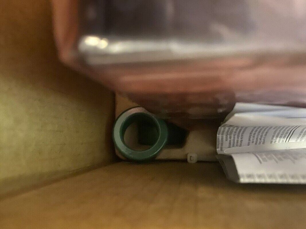 Allen-Bradley PLC component, green circular part, product documents and box visible, related to automation equipment.