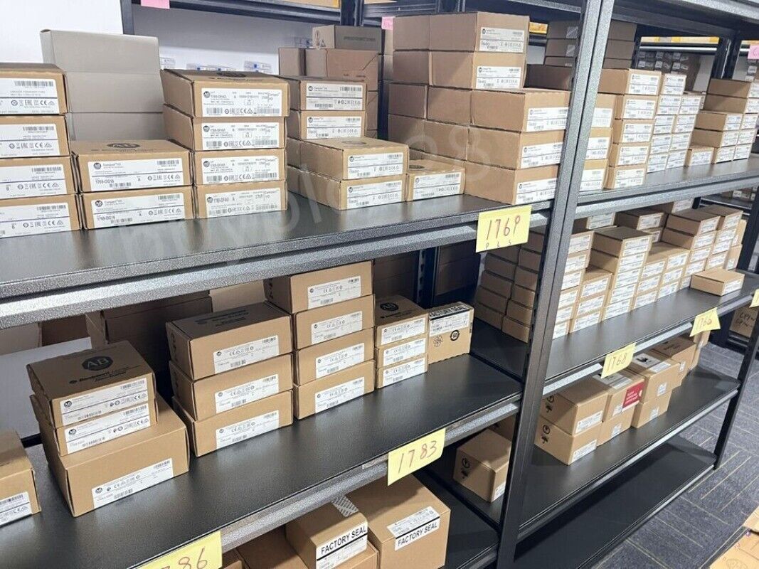 Allen-Bradley PowerFlex 4 AC Drive boxes, stacked on shelves, industrial automation parts inventory.