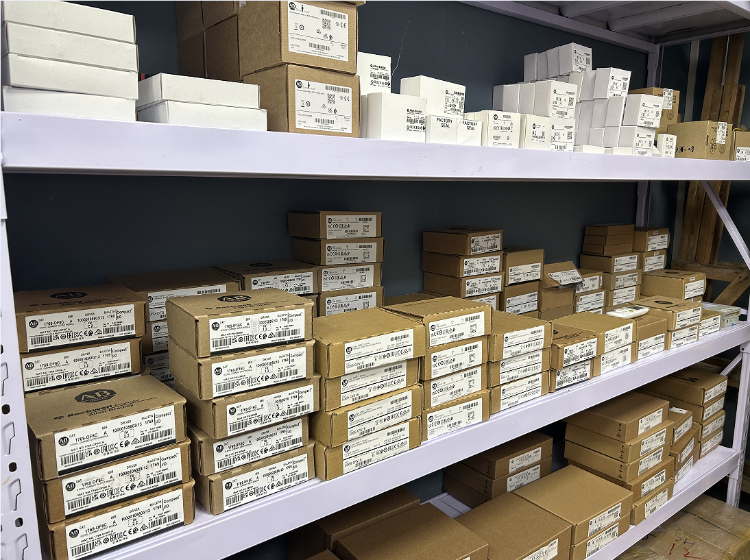 Allen-Bradley PLC modules and industrial automation spare parts on warehouse shelves, new in boxes.