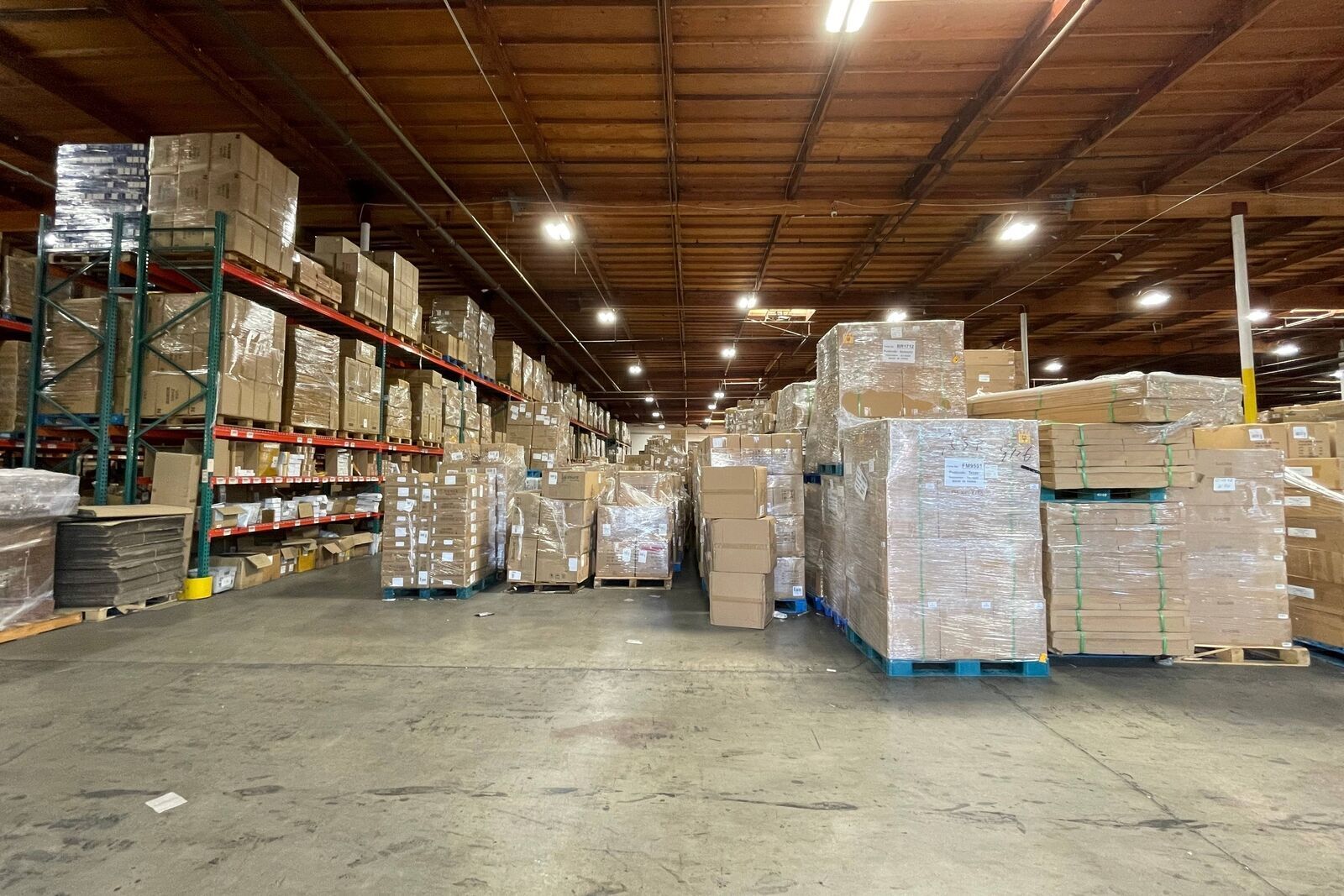 Warehouse with Allen-Bradley industrial automation parts. Boxes on shelves and pallets ready for shipment.